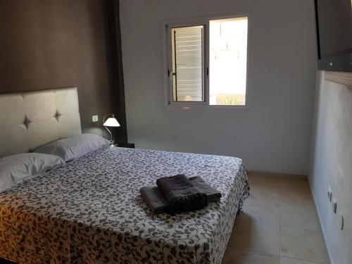 a bedroom with a bed with two towels on it at alquilaencanarias Candelaria, Terrace and Pool ! in Candelaria