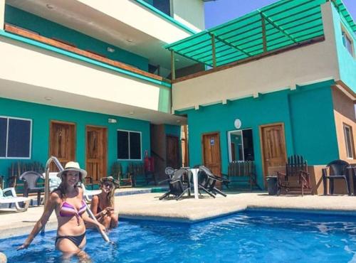 two women are sitting in a swimming pool at The Lookout Beach Hotel in San Lorenzo