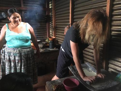 two women standing in a kitchen preparing food at Mountain Nest in Lanquín