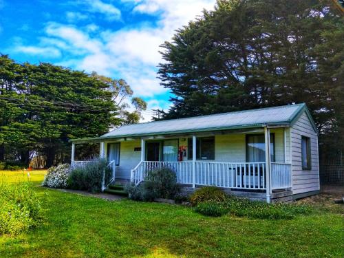 a small house with a porch on a lawn at Twelve Apostles Motel & Country Retreat in Princetown