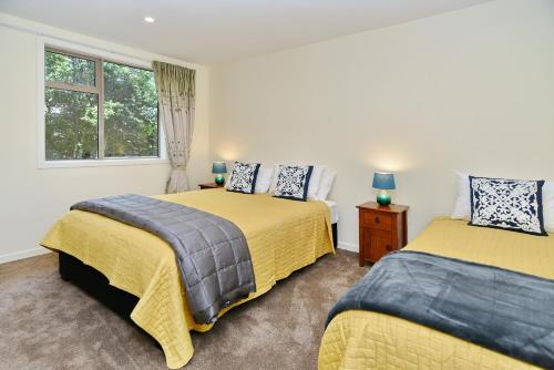 1 dormitorio con 2 camas y ventana en Clyde 106 - Christchurch Holiday Homes, en Christchurch