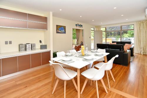 a dining room and living room with a table and chairs at Clyde 106 - Christchurch Holiday Homes in Christchurch