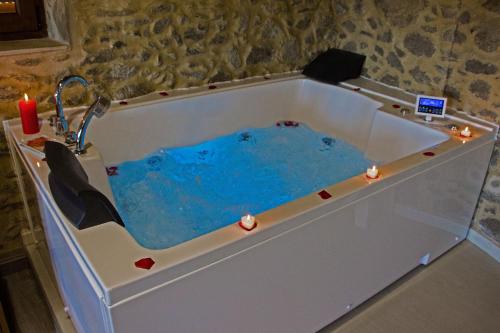 d'une baignoire remplie d'eau bleue et d'un lavabo. dans l'établissement Casa das Fiadeiras de Nemiña, à Nemiña