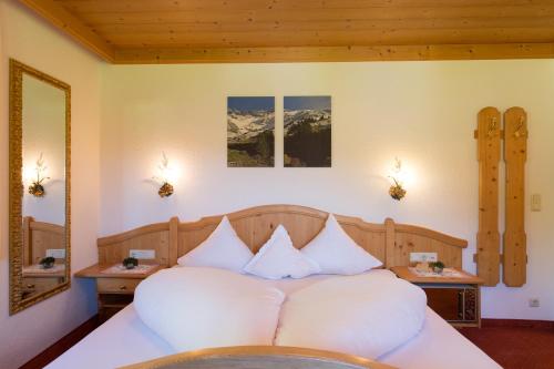 a bedroom with a large bed with white pillows at Landhaus Zauser in Sankt Anton am Arlberg