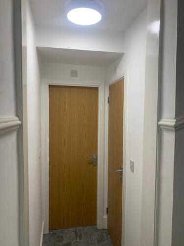 a hallway with a wooden door and a light at Be My Guest Liverpool in Liverpool