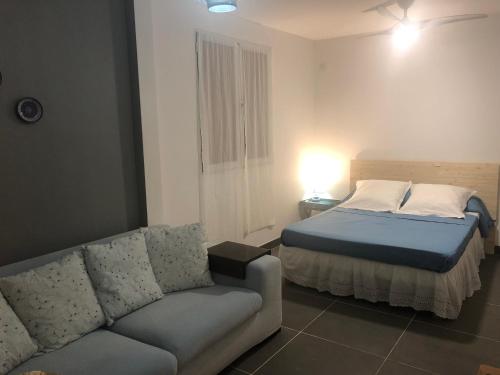 a bedroom with a bed and a couch at Bleu Cannelle et Petimo in Le Diamant