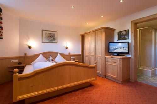 1 dormitorio con 1 cama y TV en Landhaus Zauser, en Sankt Anton am Arlberg