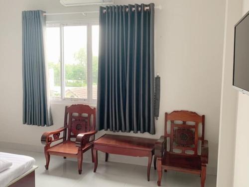 a living room with two chairs and a window at Phong Lan Guesthouse in Chau Doc