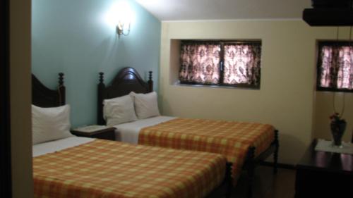 a hotel room with two beds and two windows at Residencial Porto Novo - Alojamento Local in Porto