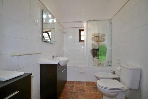 a white bathroom with a toilet and a sink at Horta Nova in Lagos