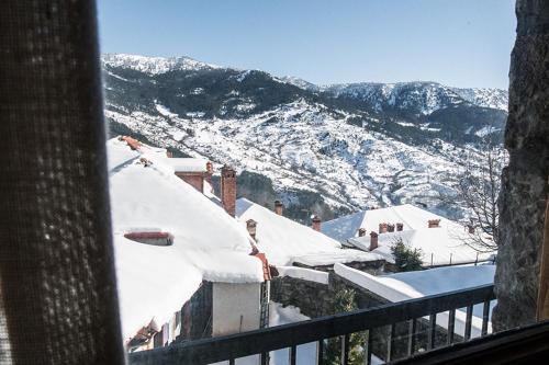 a view of a snow covered mountain from a balcony at Filoxeni Gonia in Metsovo