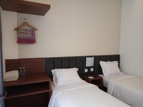 Postel nebo postele na pokoji v ubytování Alzara Hotel Syariah