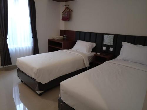 Postel nebo postele na pokoji v ubytování Alzara Hotel Syariah