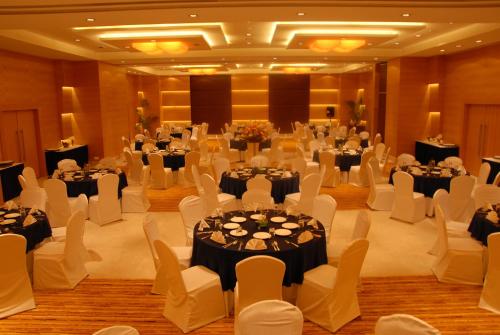 a banquet hall with white tables and white chairs at Mysore County Retreat in Mysore