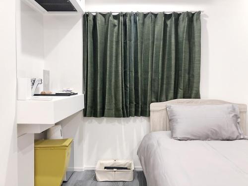 1 dormitorio con 1 cama y cortina verde en ZAITO Tokyo Chitose Accommodation 森下駅から徒歩6分, en Tokio