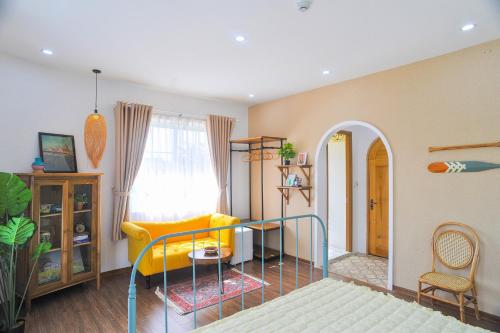 a living room with a yellow couch and a table at NẮNG House in Da Nang