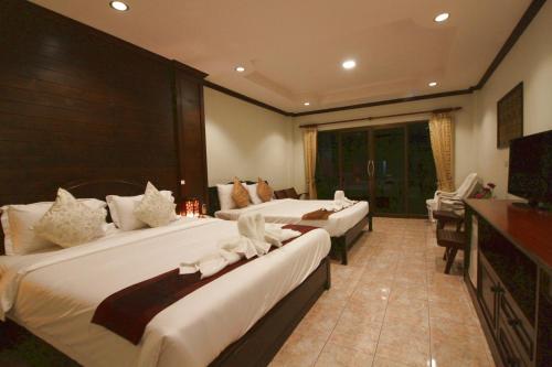 Postel nebo postele na pokoji v ubytování Baan Veerakit Hotel