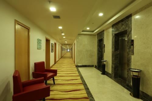 a corridor of a hallway with chairs and a long hallway at Mysore County Retreat in Mysore