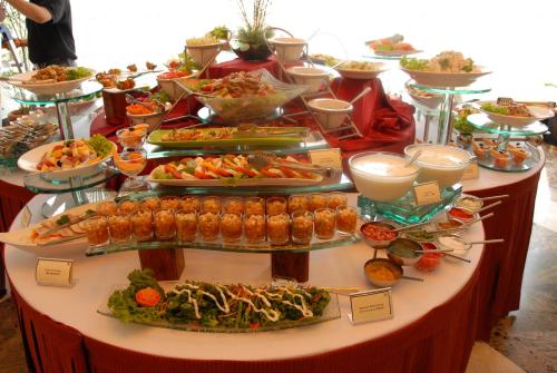 a buffet with many plates of food on a table at Mysore County Retreat in Mysore