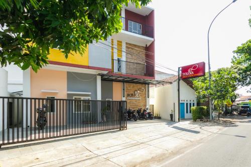 a building with a fence in front of a street at RedDoorz Syariah near Purwosari Train Station in Solo