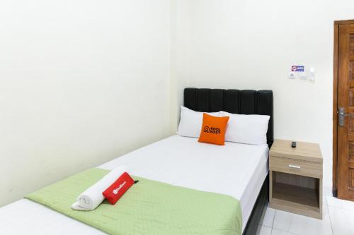 um quarto com uma cama com duas almofadas em RedDoorz Syariah near Purwosari Train Station em Surakarta