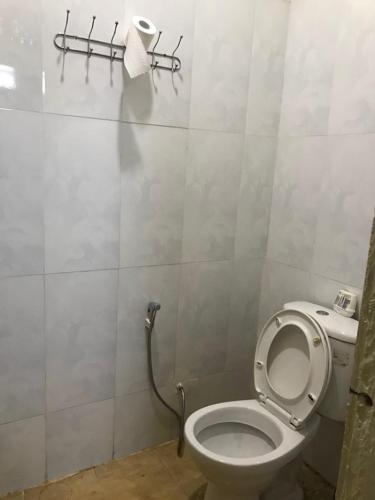 a bathroom with a toilet and a roll of toilet paper at Manel Guesthouse and Restaurant in Sen Monorom