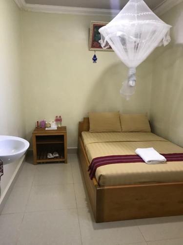 a bedroom with a bed and a tub and a sink at Manel Guesthouse and Restaurant in Sen Monorom