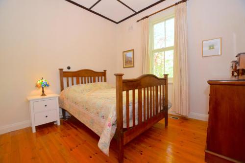 a bedroom with a bed and a window at Mintie Cottage on Leura Mall in Leura