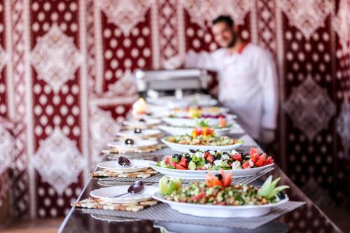 a long table with plates of food on it at Arena Desert Camp & Adventurers in Wadi Rum