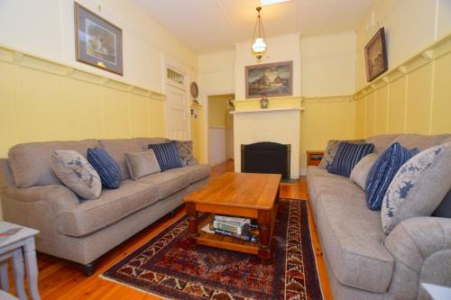 a living room with two couches and a coffee table at Mintie Cottage on Leura Mall in Leura