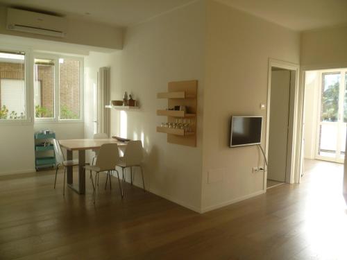 a living room with a table and chairs and a television at Suite Mare Centro in Pesaro