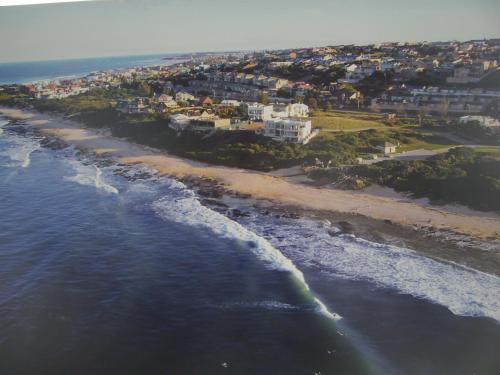 an aerial view of the shoreline of a beach at At the Beach in Jeffreys Bay