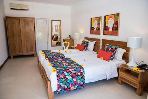 two large beds in a room with red pillows at Villas Mon Plaisir in Pointe aux Piments