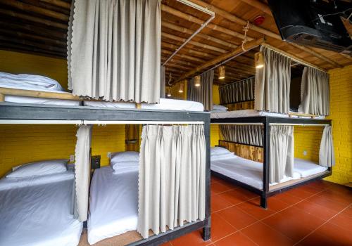 three bunk beds in a room with curtains at Mira Bãi Xếp Quy Nhơn - The Hidden Jewel in Quy Nhon