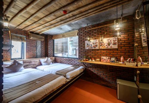 two beds in a room with a brick wall at Mira Bãi Xếp Quy Nhơn - The Hidden Jewel in Quy Nhon