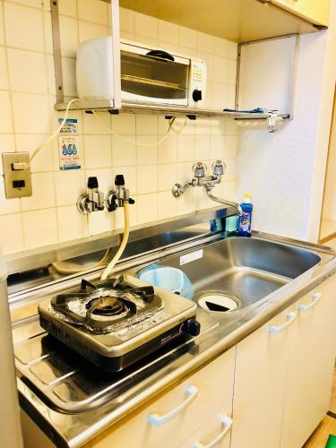 a kitchen with a stove and a sink at Ichijyo Ivy in Kyoto
