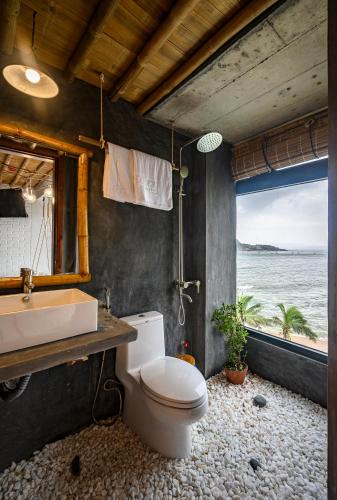 a bathroom with a toilet and a sink and a window at Mira Bãi Xếp Quy Nhơn - The Hidden Jewel in Quy Nhon