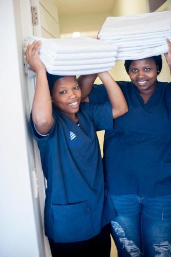 a man and a woman holding a stack of plates at Plett Beachfront Accommodation in Plettenberg Bay