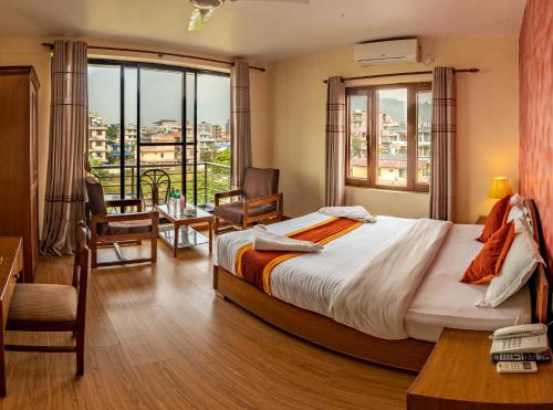 a hotel room with a bed and a large window at Hotel Pokhara View in Pokhara