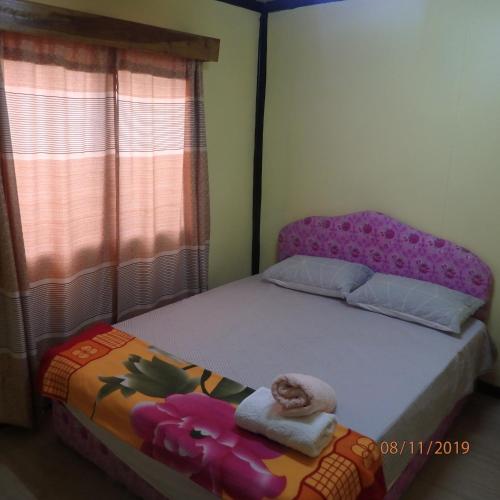 a small bedroom with a bed and a window at Classixx Inn in Nausori