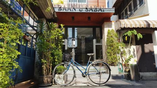 Una bicicleta azul estacionada frente a un edificio en Baan U-Sabai บ้านอยู่สบาย, en Bangkok