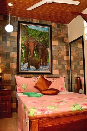 a bedroom with a bed with a picture of elephants at Linda Cottage in Galle
