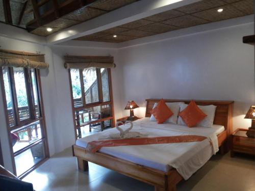 um quarto com uma cama num quarto com janelas em Nigi Nigi Nu Noos 'e' Nu Nu Noos em Boracay