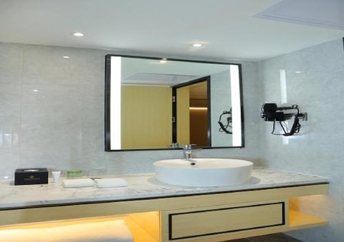 a bathroom with a sink and a large mirror at Landmark International Hotel in Guangzhou