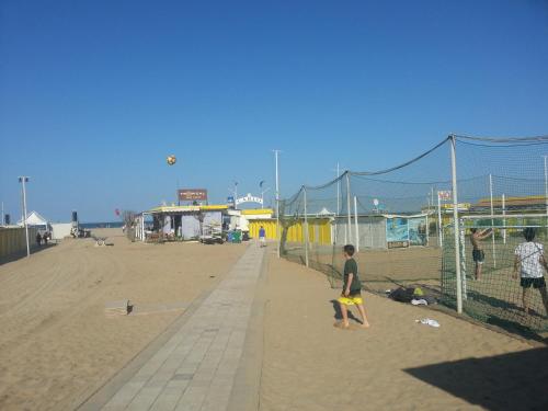 een groep mensen die volleyballen op het strand bij Hotel Trinidad in Rimini