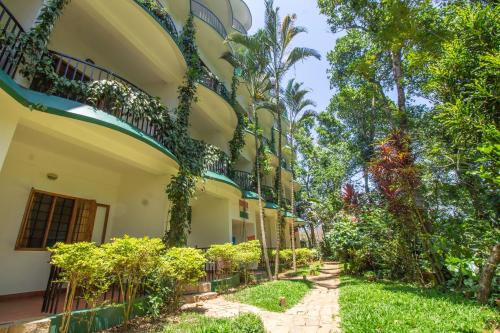 a courtyard of a building with plants and trees at Chrissie's Hotel in Thekkady