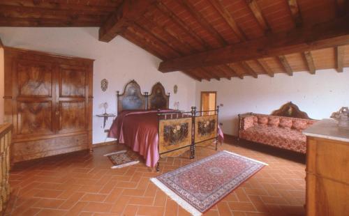 um quarto com uma cama e um sofá num quarto em Fattoria di Belvedere em Poppi