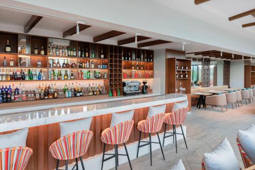 a bar in a restaurant with orange and white chairs at Gran Melia Arusha in Arusha