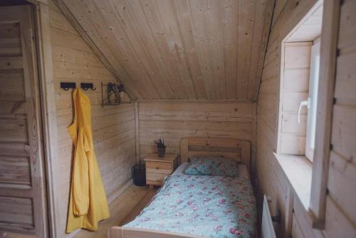 a small bedroom with a bed in a wooden cabin at Fjordcottage in Søldarfjørður