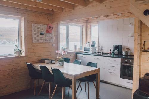 a kitchen with a table and chairs in a room at Fjordcottage in Søldarfjørður